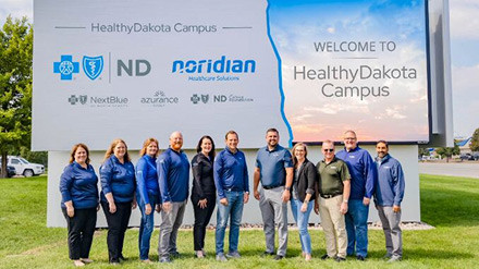 Executives standing in front of HealthyDakota sign