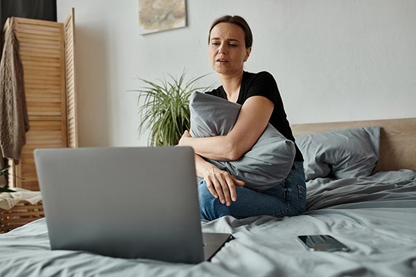 Woman sitting in bed using a laptop